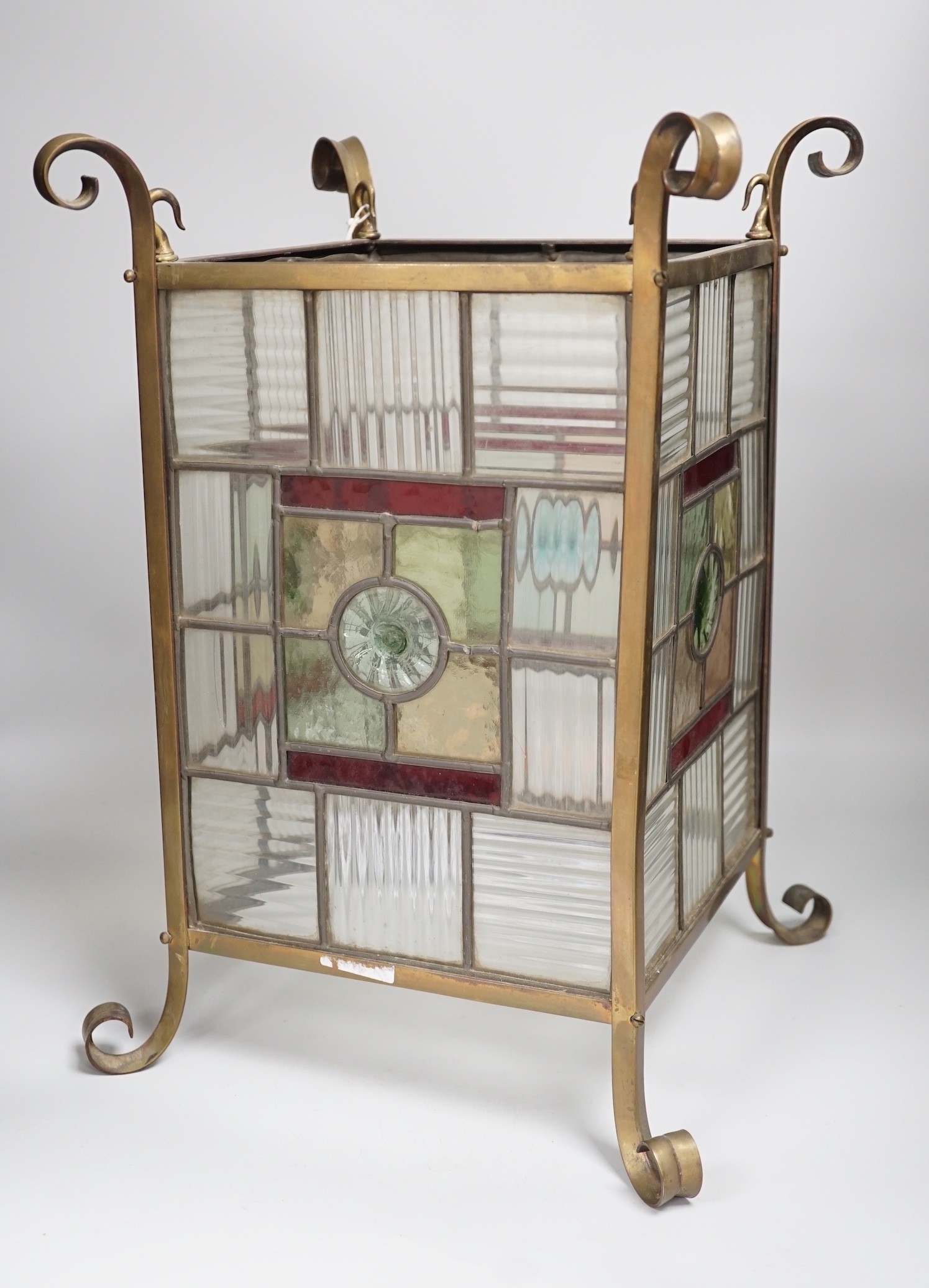 An Arts and Crafts brass and stained glass porch lantern. 46cm tall
